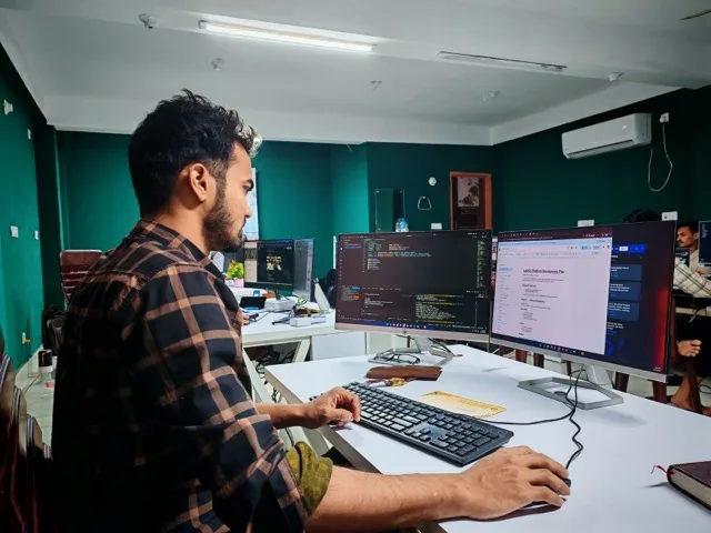 Fejlesztő csapat code review-t tart a monitor előtt
